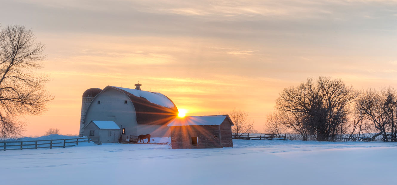 Sunrise over a snow blanketed farm.